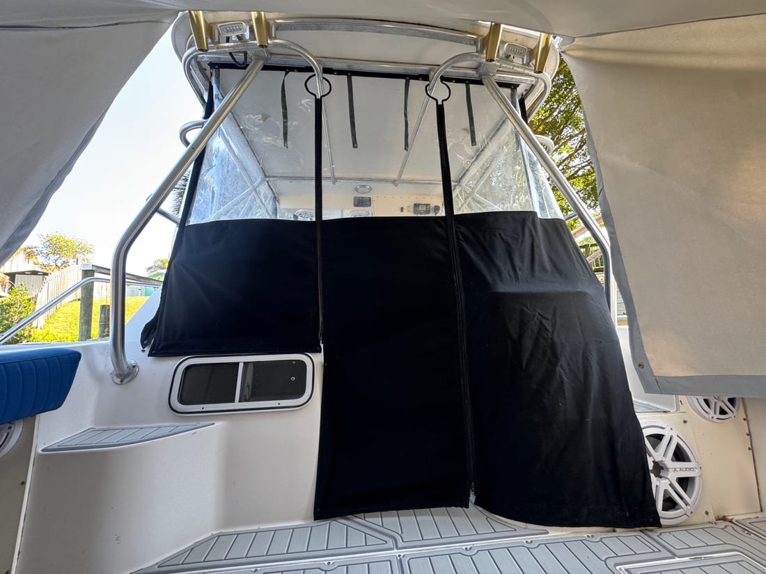Black canvas aft curtain with clear vinyl panels closing in a boat's cockpit
