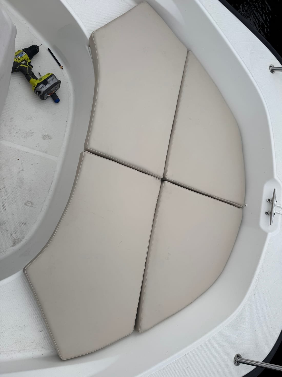 Four tan vinyl cushion panels fitted into the bow of a boat