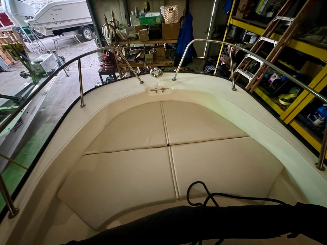 Cream vinyl bow cushions fitted into a boat's forward seating inside the workshop