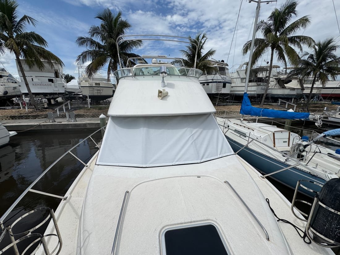 White canvas cover enclosing the flybridge helm of a boat at its dock