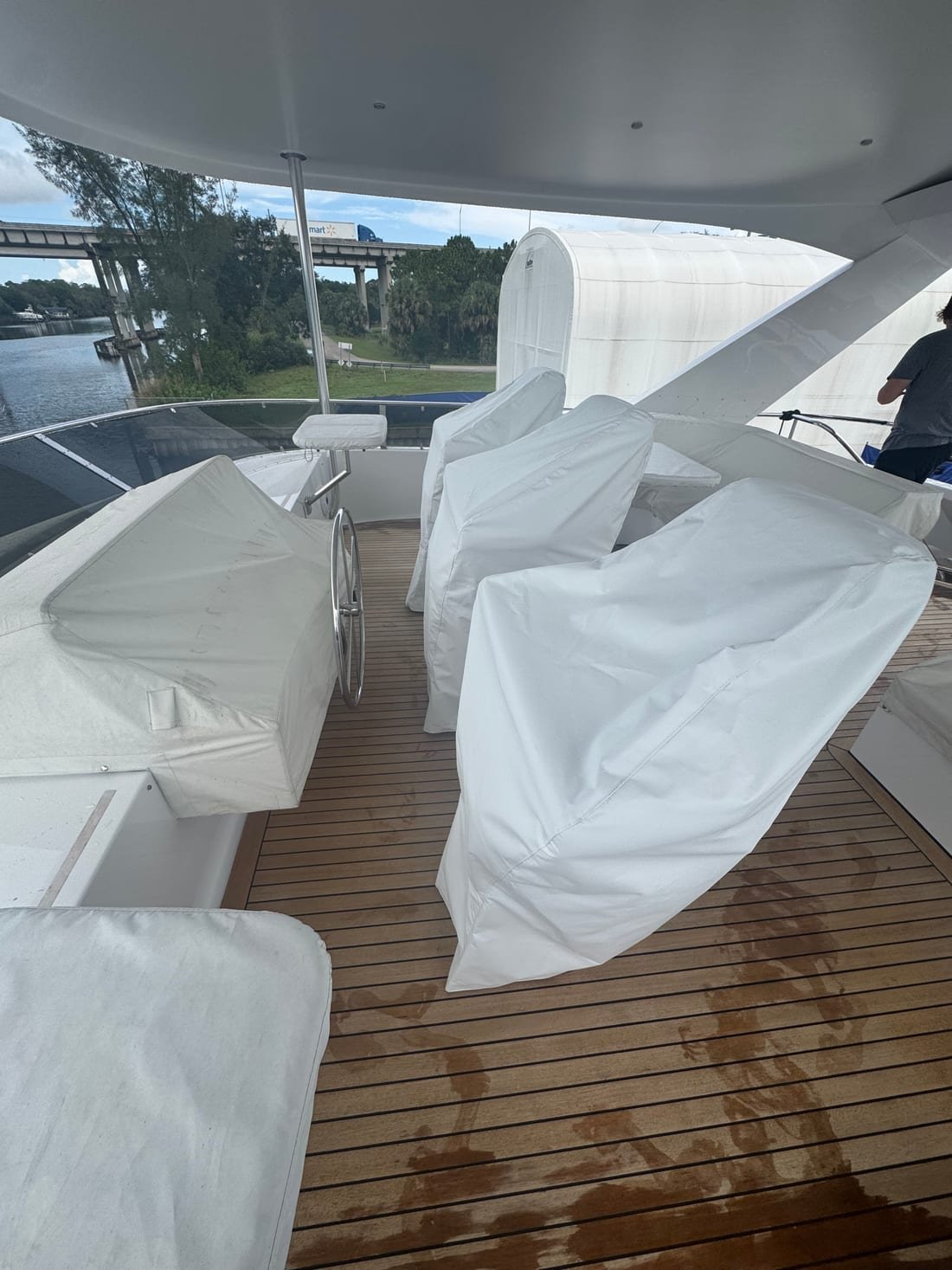 White canvas covers over helm chairs and settees on a yacht's teak flybridge