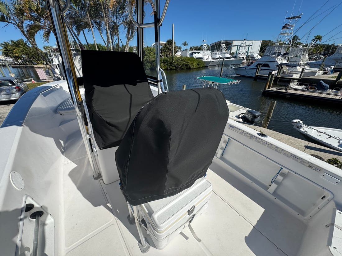 Black canvas covers fitted over a pair of helm seats on a center console