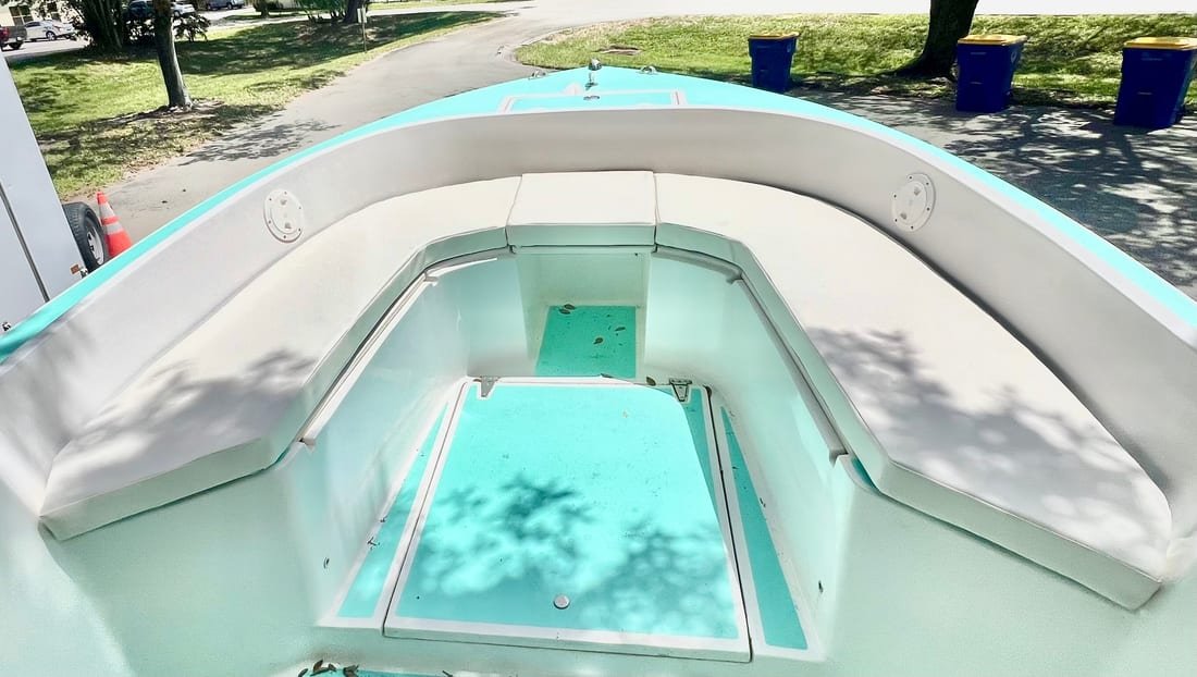 White vinyl bow cushions in the forward seating of a seafoam-green flats skiff