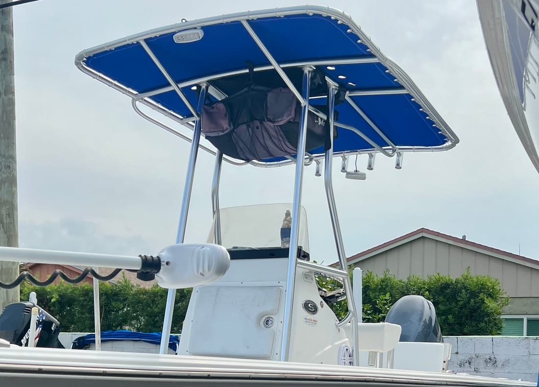 Royal blue canvas T-top canopy stretched over the console of a center console boat