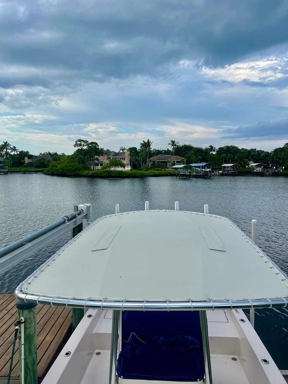 White canvas T-top seen from the bow of a boat docked on the Intracoastal at dusk